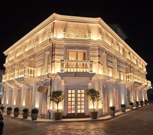 a white building with a lit up facade at night at Giulia Albérgo Hotel in Durrës
