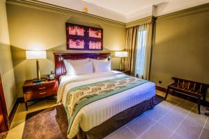 pokój hotelowy z dużym łóżkiem i 2 lampami w obiekcie Somewhere Hotel Apartment w Dubaju