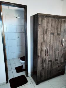une salle de bain avec toilettes et porte en bois dans l'établissement Apartamento aconchegante no Jardim Paulistano, à Campina Grande