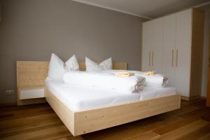 1 dormitorio con 1 cama con sábanas y almohadas blancas en Ferienhaus Schiestl en Wiesing