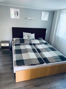 Una cama con una manta a cuadros en blanco y negro. en Bitter súkromné ubytovanie, en Štúrovo