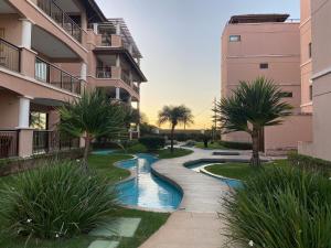 una pasarela entre dos edificios de apartamentos con palmeras en Beverlly Hills, en Aquiraz