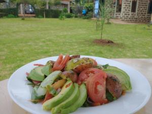 Home of Friends في Kapchorwa: طبق من الطعام مع الخضروات على الطاولة