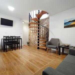 a living room with a spiral staircase and a table and chairs at Dúplex Costa de Fisterra II in Finisterre