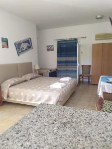 a bedroom with two beds and a table and a chair at Nicolas Apartments in Ierapetra