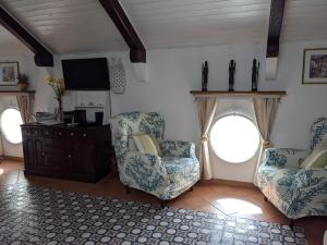 sala de estar con 2 sillas y TV en Casa Giovanna Positano, en Positano
