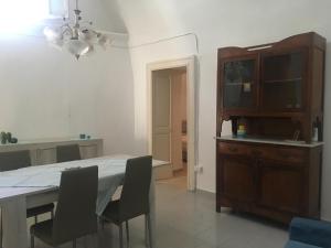 een keuken en eetkamer met een tafel en stoelen bij Salento, casa tipica in Sternatia