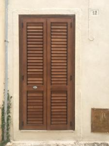 een houten deur aan de zijkant van een gebouw bij Salento, casa tipica in Sternatia