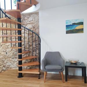 a chair next to a spiral staircase with a table at Dúplex Costa de Fisterra II in Finisterre