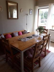 una mesa de madera en una sala de estar con sillas en B&B Parksäter en Håcksvik