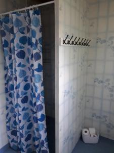 a bathroom with a blue and white shower curtain at B&B Parksäter in Håcksvik