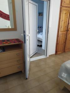 a bedroom with a sliding door and a mirror at Nicolas Apartments in Ierapetra