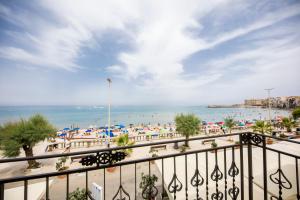 een uitzicht op een strand met parasols en de oceaan bij Abelia Sea Suites in Cefalù