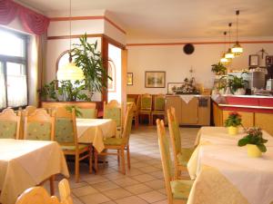 a restaurant with tables and chairs and a kitchen at Hotel Gasthof WASTL in Appiano sulla Strada del Vino