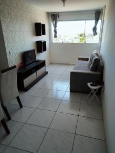 ein Wohnzimmer mit einem Sofa und einem Tisch in der Unterkunft Apartamento aconchegante no Jardim Paulistano in Campina Grande