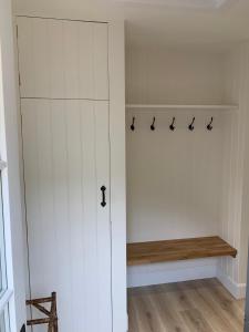 a white closet with a bench in a room at The Bothy at Arndean in Dollar