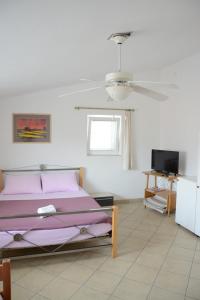 ein Schlafzimmer mit einem Bett und einem Deckenventilator in der Unterkunft Apartments Marina in Ražanac