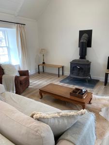 a living room with a couch and a fireplace at The Bothy at Arndean in Dollar