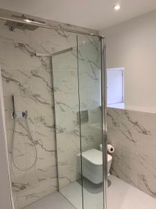 a bathroom with a glass shower with a toilet at The Bothy at Arndean in Dollar