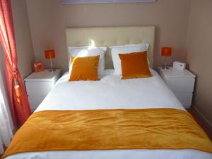 1 dormitorio con 1 cama grande con almohadas de color naranja en Luxury Orange Paris Disneyland, en Serris
