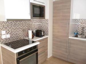 uma cozinha com um lavatório e um fogão forno superior em Luxury Orange Paris Disneyland em Serris