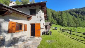 a house with an orange door and a grass yard at Chalet Courmayeur in Courmayeur