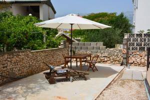 eine Terrasse mit Tisch und Sonnenschirm in der Unterkunft Apartments Marina in Ražanac