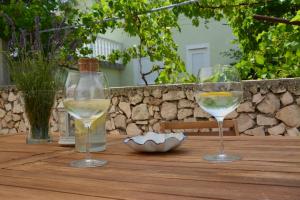 zwei Gläser Weißwein auf einem Holztisch in der Unterkunft Apartments Marina in Ražanac