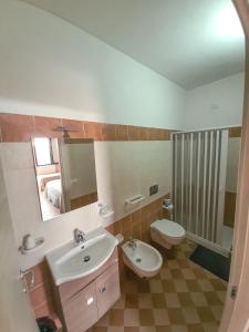 un bagno con lavandino, WC e specchio di Locanda Adele a Parghelia