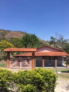 une petite maison avec une clôture devant dans l'établissement Chácara meu doce, à Socorro