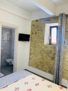 a bedroom with a bed and a stone wall at Casa castello in Rocca Imperiale