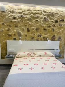 a bedroom with a bed and a stone wall at Casa castello in Rocca Imperiale