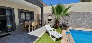 une terrasse avec une table, des chaises et une piscine dans l'établissement Villa Nour, à Fès