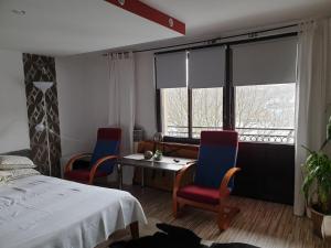 sypialnia z 2 krzesłami, stołem i łóżkiem w obiekcie słoneczne apartamenty w Krościenku