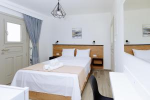 1 dormitorio blanco con 1 cama y 1 silla en Ilios house, en Kavala