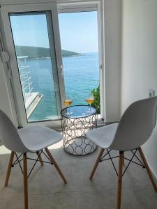 a room with two chairs and a table with a view of the ocean at Azzure Apartment in Ulcinj