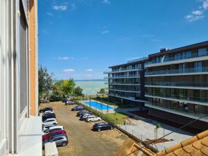 a parking lot with cars parked next to a building at Surman Apartmanok in Siófok