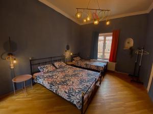a bedroom with two beds and a table and a chandelier at Corner Guest House in Tbilisi City