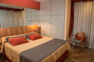 科尔多瓦King David Flat Hotel - Argentina的一间卧室配有一张带两个橙色枕头的床