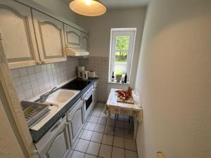 a small kitchen with a sink and a window at NTAB10001-FeWo-Moeoevwarder in Neue Tiefe Fehmarn