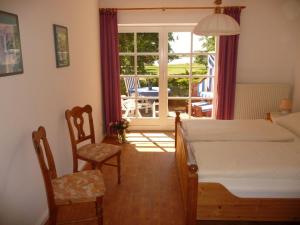 a bedroom with a bed and a table and chairs at NTAB10001-FeWo-Moeoevwarder in Neue Tiefe Fehmarn