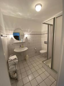 a white bathroom with a sink and a mirror at NTAB10002-FeWo-Moeoevwarder-twee in Neue Tiefe Fehmarn