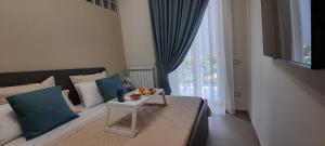 a bedroom with a bed with blue pillows and a table at Vesuvius' Lovely Inn in Ercolano