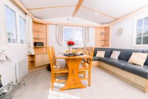 un soggiorno con un tavolo e un divano di LE COTTAGE DE LYXIE-Nature et sports a Talmont