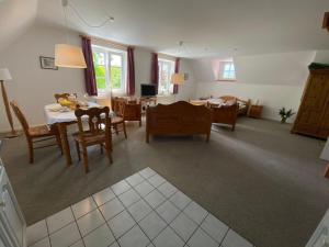 a dining room and living room with a table and chairs at NTAB10104-FeWo-Moeoevwarder-veer in Neue Tiefe Fehmarn