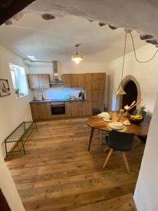 uma cozinha e sala de jantar com uma mesa de madeira em Appartamento Saeculum em Egna