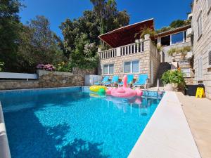 - une piscine avec des chaises et une maison dans l'établissement Bed and Breakfast Villa Klaic, à Dubrovnik