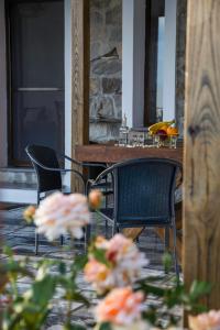 dwa krzesła i stół oraz kwiaty na patio w obiekcie Villa Aloni in Triopetra w mieście Triopetra