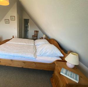 sypialnia z łóżkiem z drewnianym zagłówkiem w obiekcie NTAB10105-FeWo-Moeoevwarder-fief w mieście Neue Tiefe Fehmarn