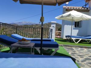 une terrasse avec une table, des chaises et un parasol dans l'établissement Villa Las Encinas COSTA DEL SOL, à Torrox